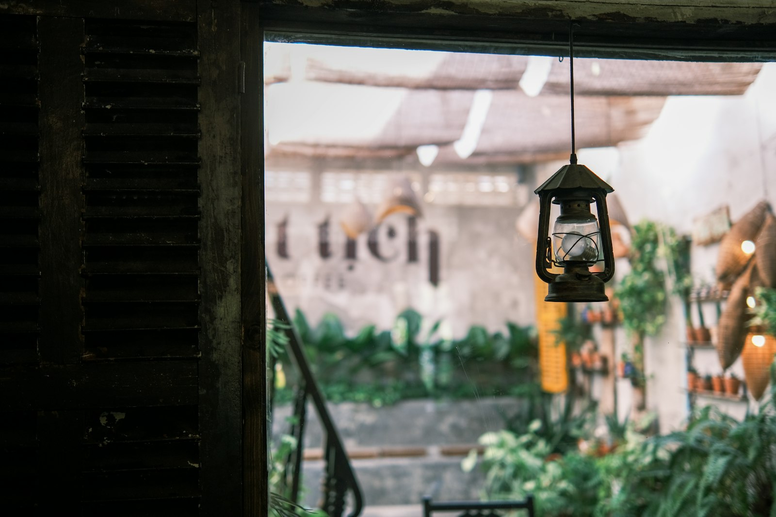 Quán cafe vintage Việt — đèn dầu cổ điển, lá cọ, không khí mộc