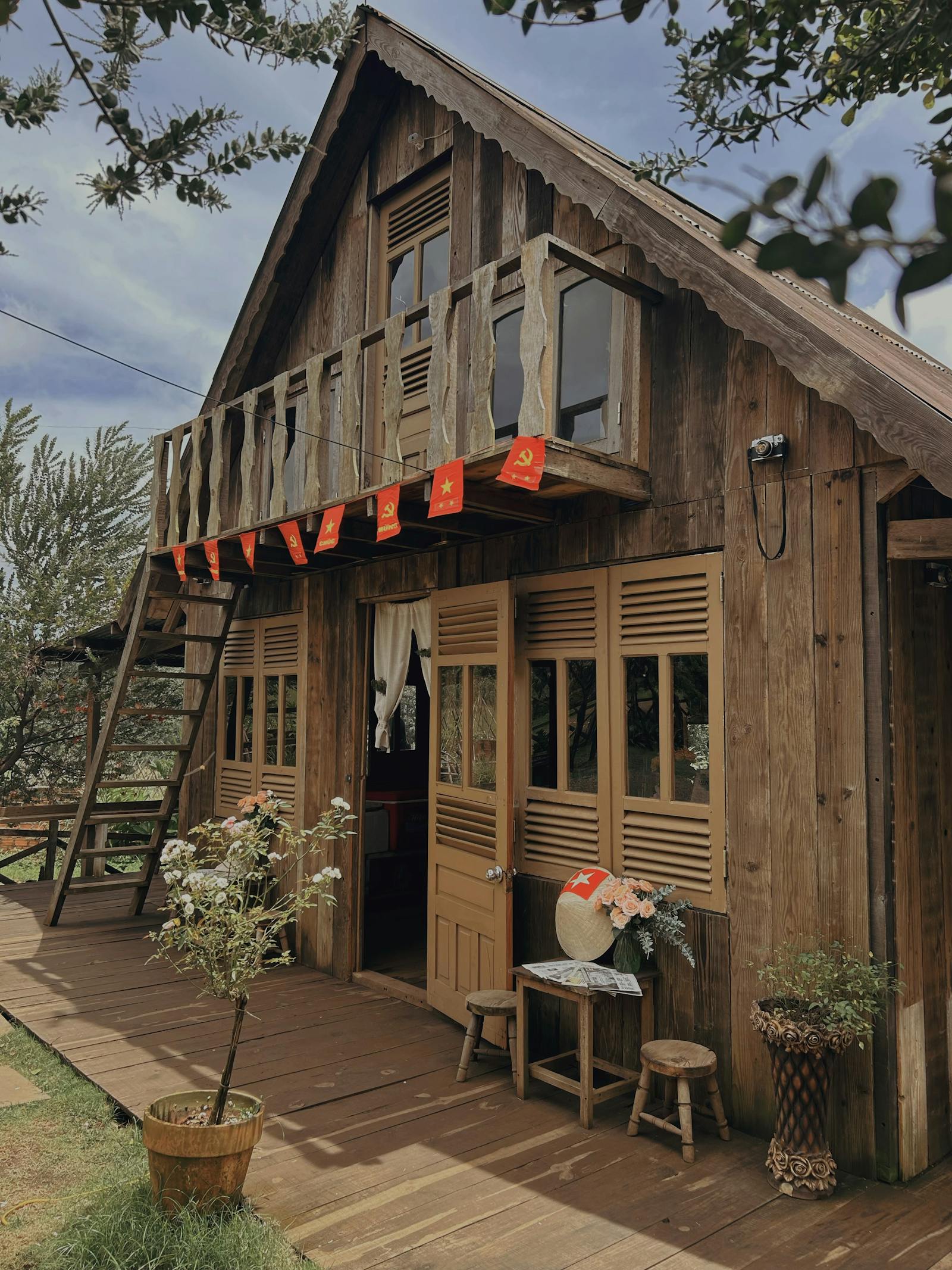 Nhà gỗ kiểu homestay/cafe Pleiku có cờ Việt Nam và nón lá